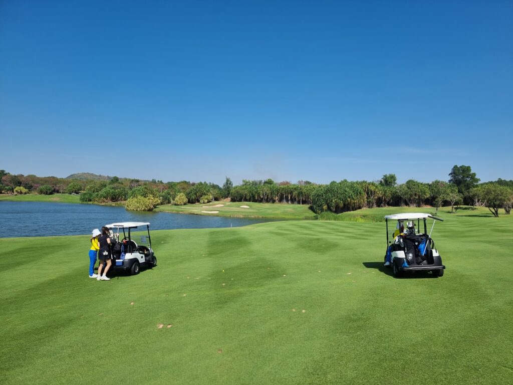 파타야 시암CC 워터사이드 골프장 전경, 푸른 잔디와 맑은 하늘이 어우러진 풍경입니다.