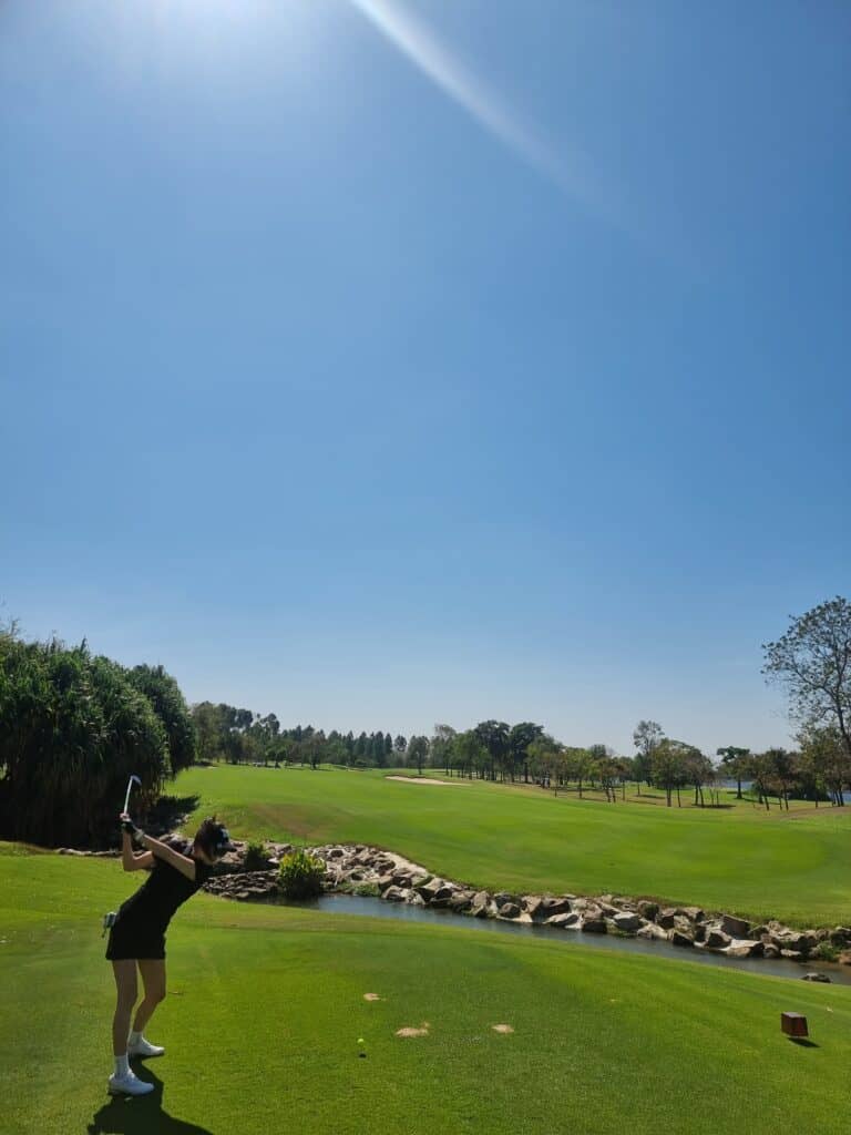 파타야 골프장 풍경, 맑은 하늘과 푸른 잔디, 골프 연습하는 사람 모습이 담긴 이미지입니다.