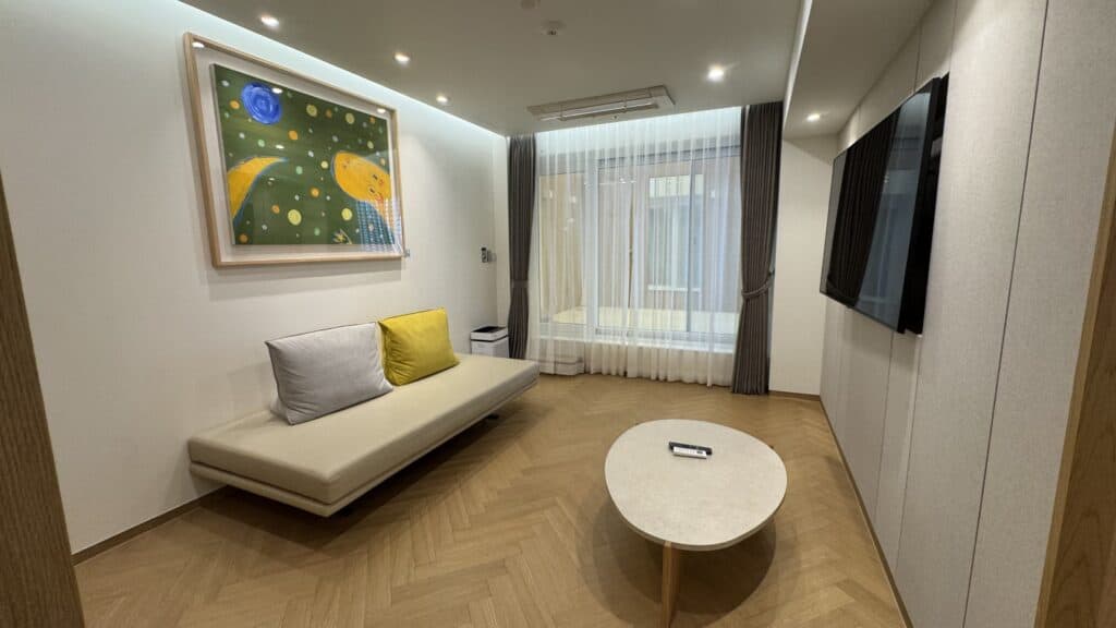 Interior of the Suite room at Deokgu Hot Springs Hotel, featuring a comfortable sofa and a bright, naturally lit space.