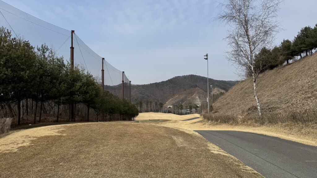 화성상록CC 골프장 전경, 푸른 하늘과 넓은 페어웨이, 주변 자연 풍경이 어우러진 모습입니다.