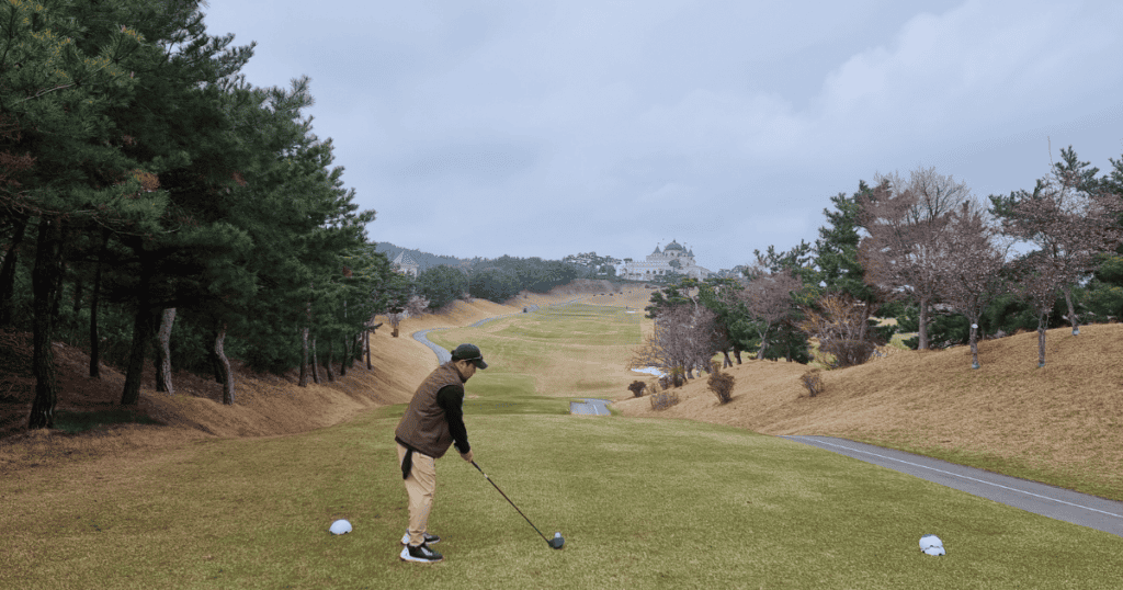 서산수CC 골프 연습장에서 골프공 치는 모습, 자연 풍경과 푸른 잔디.